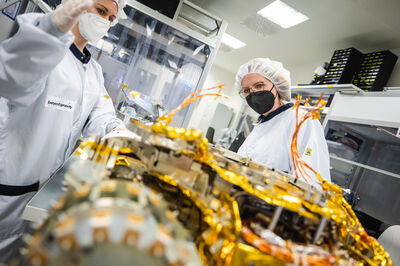 © BMK/Perwein Klimaschutzministerin Leonore Gewessler (rechts) besuchte im April 2022 die Weltraumelektronikproduktion in einem Reinraum von Beyond Gravity Austria in Wien.